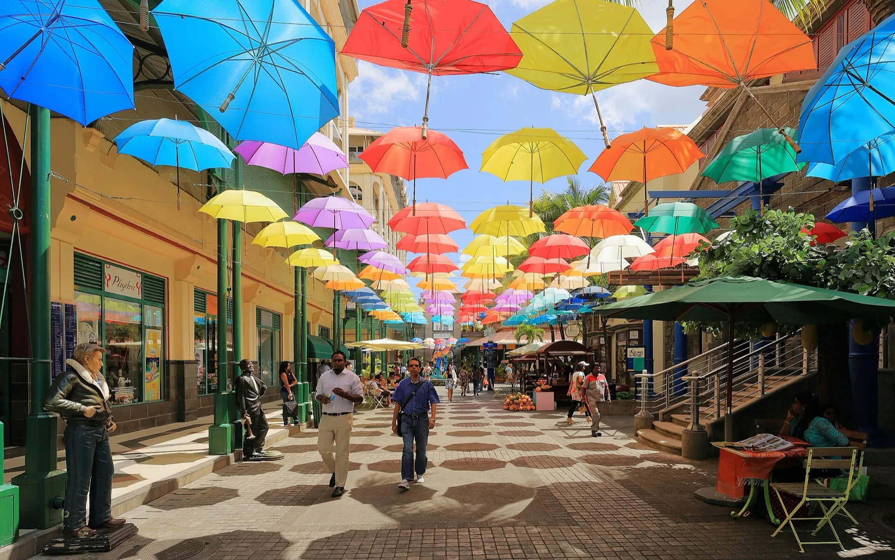 Rue piétonne du Caudan Waterfront à Port-Louis, ornée d'ombrelles colorées suspendues